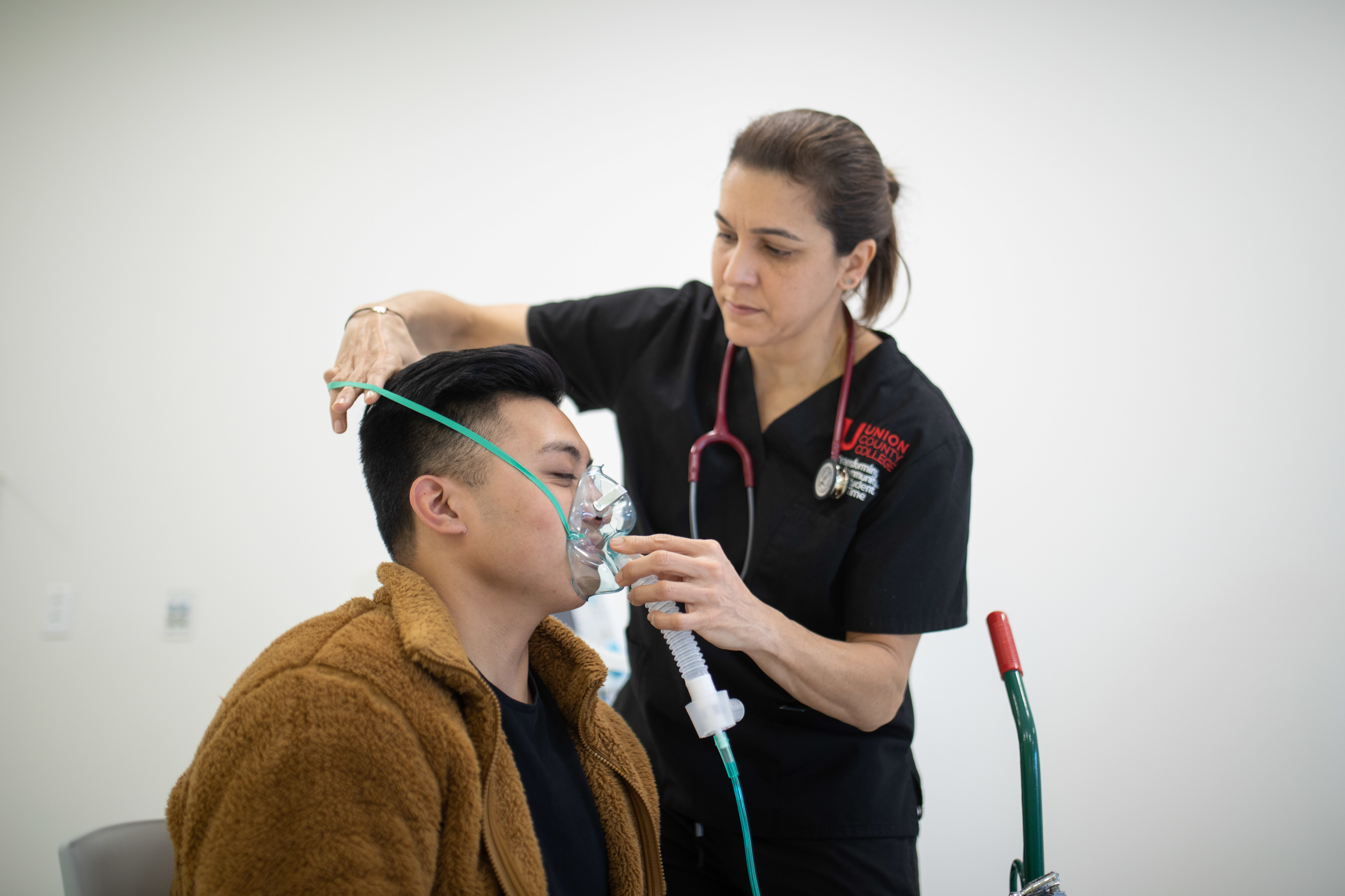 A student placing an oxygen mask on a person.